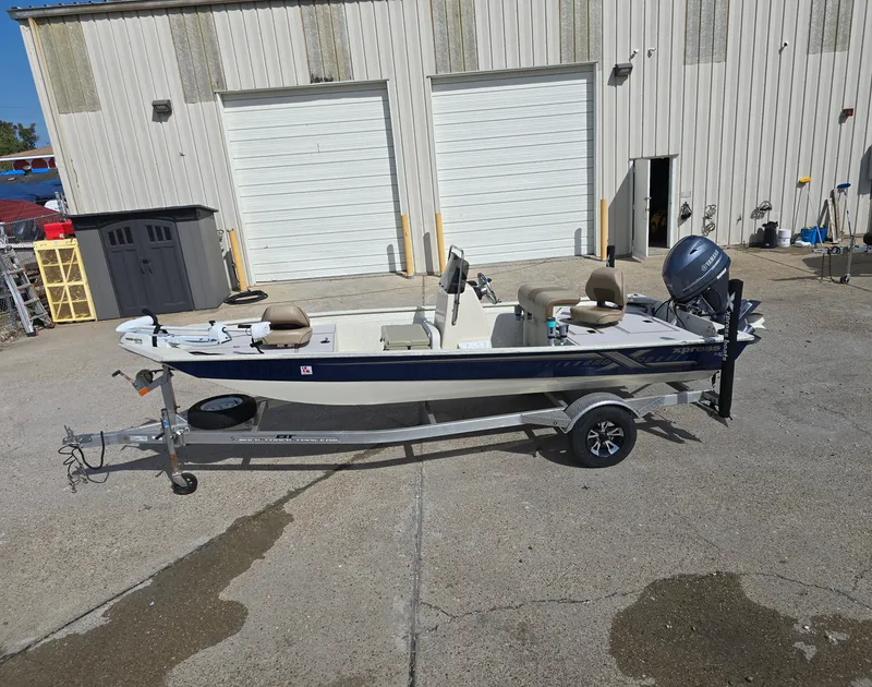 Slide: The Image of 2020 Xpress XP18CC boat on trailer, parked outside industrial building. - 1