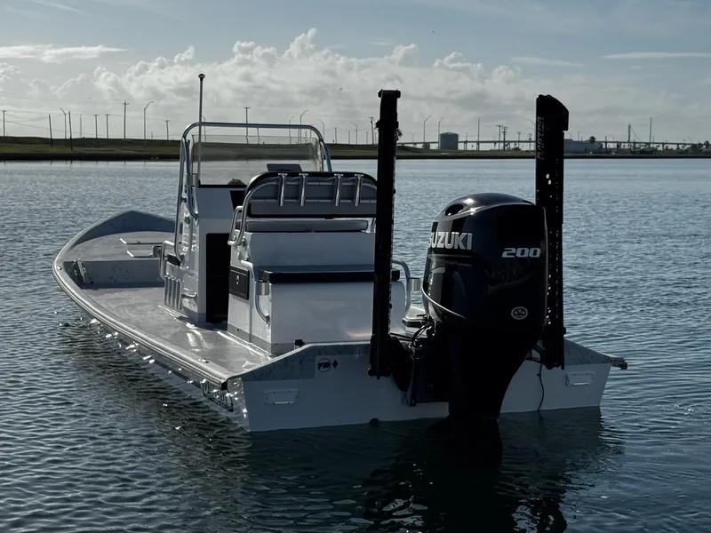 Slide: The Image of 2024 Mowdy 25 Catamaran with Suzuki 200 engine on calm water. - 0