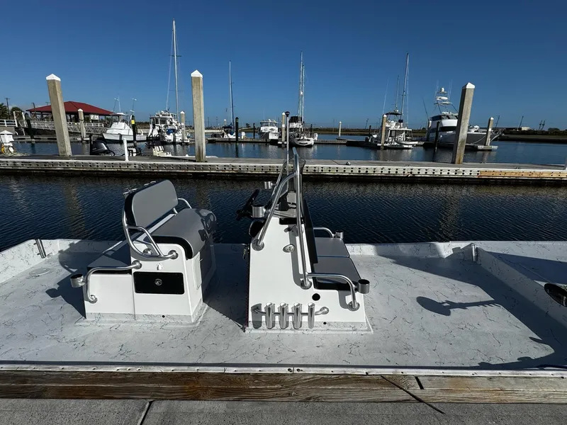 Slide: The Image of 2024 Mowdy 25 Catamaran docked at marina with boats in background. - 10
