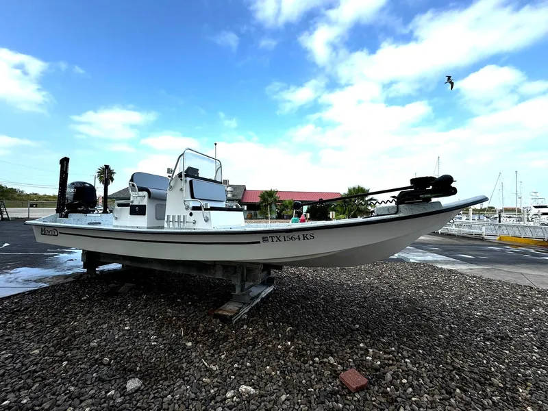 Slide: The Image of 2024 Mowdy 25 Catamaran boat on gravel lot under blue sky. - 13