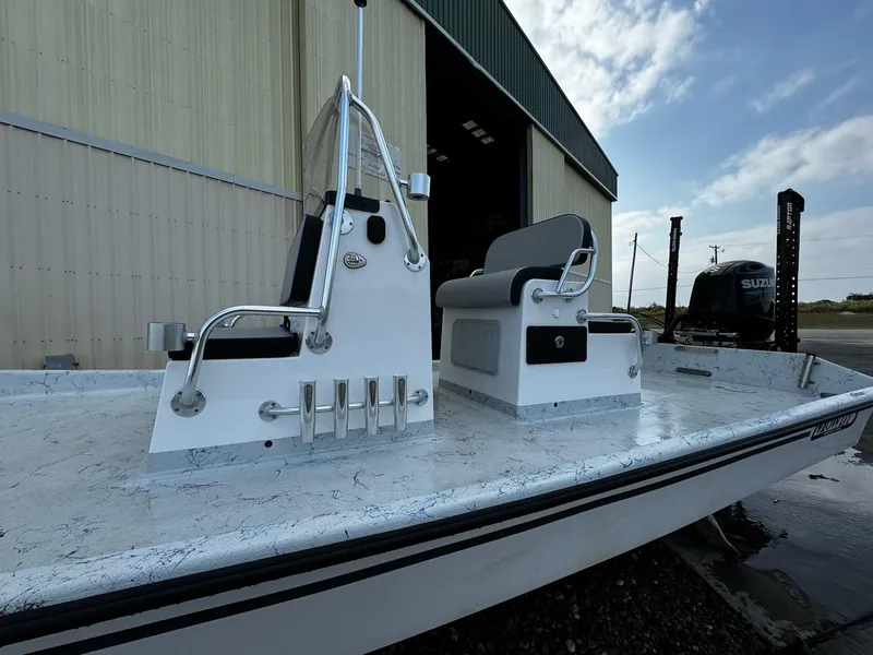 Slide: The Image of 2024 Mowdy 25 Catamaran boat with dual seating, docked near a warehouse. - 15