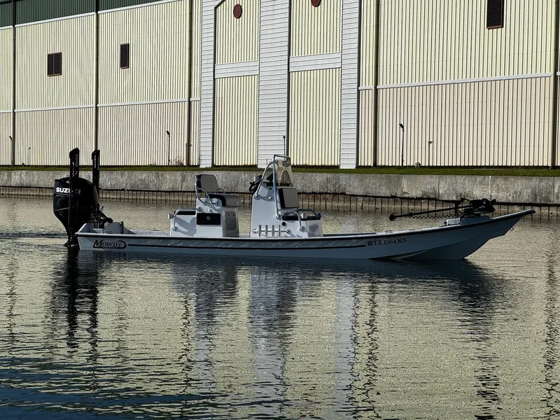 Slide: The Image of 2024 Mowdy 25 Catamaran boat on calm water near a warehouse. - 2