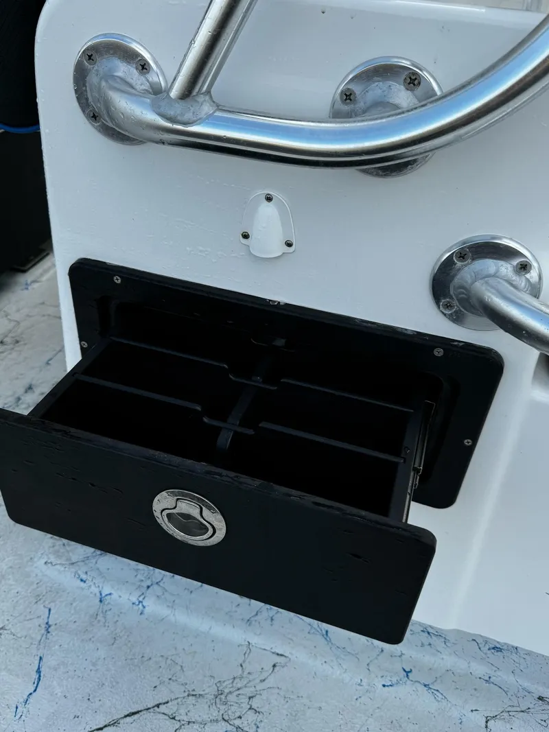 Slide: The Image of 2024 Mowdy 25 Catamaran storage compartment with stainless steel handles. - 22