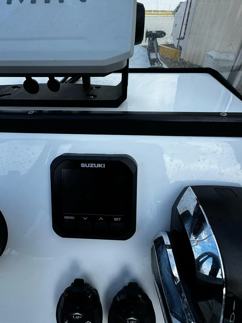 Slide: The Image of 2024 Mowdy 25 Catamaran dashboard with Suzuki controls and electronics. - 26