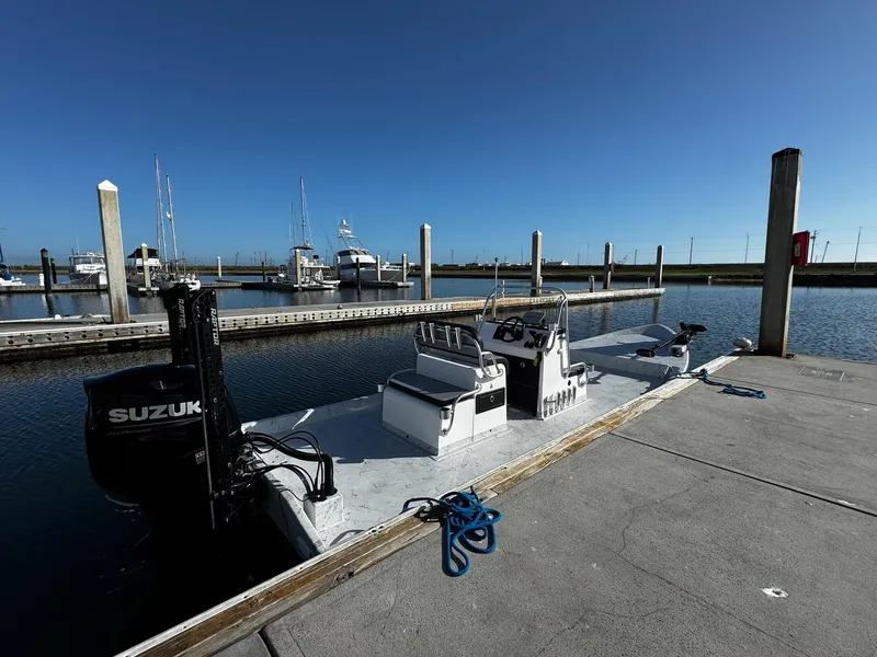 Slide: The Image of 2024 Mowdy 25 Catamaran docked at marina with Suzuki outboard motor. - 6