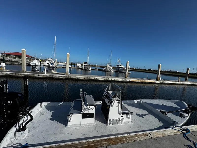 Slide: The Image of 2024 Mowdy 25 Catamaran docked at a marina with clear blue skies. - 7