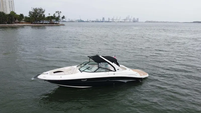 Slide: The Image of 2008 Sea Ray 290 SLX boat on calm waters near a city shoreline. - 22