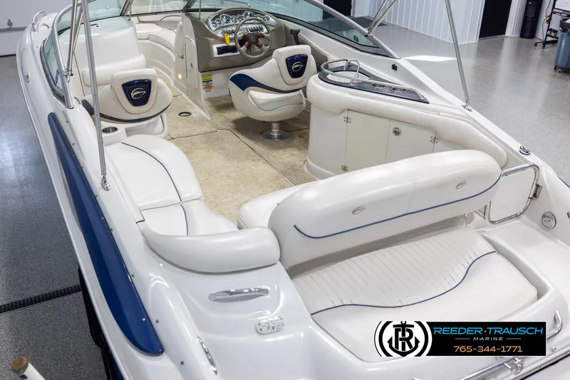 Slide: The Image of 2008 Crownline 240 EX boat interior with white seating and dashboard, displayed in showroom. - 11