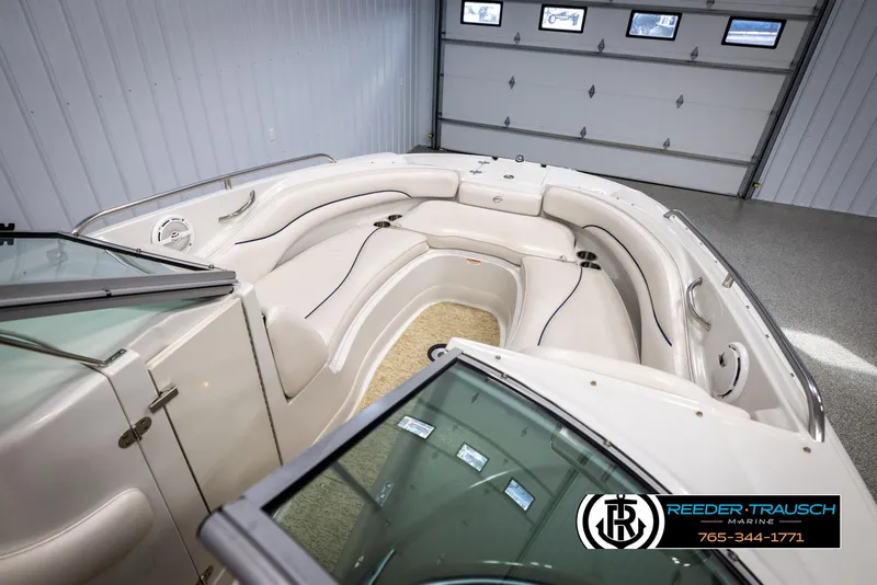 Slide: The Image of 2008 Crownline 240 EX boat interior with white seating in a garage. - 19