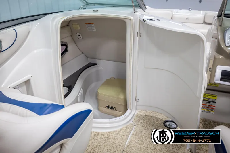 Slide: The Image of 2008 Crownline 240 EX boat interior with open compartment and portable toilet. - 23