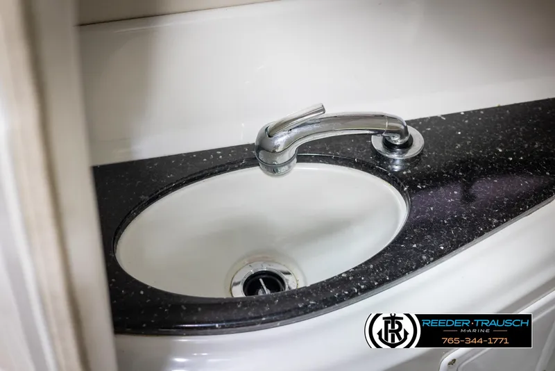 Slide: The Image of 2008 Crownline 240 EX boat sink with sleek faucet and black countertop. - 25