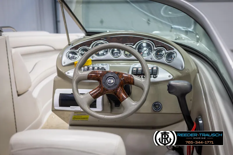 Slide: The Image of 2008 Crownline 240 EX boat dashboard with wood-accented steering wheel and instrument panel. - 26