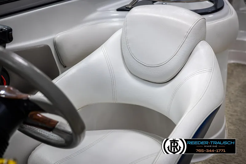 Slide: The Image of White leather seat in 2008 Crownline 240 EX boat interior, featuring steering wheel and logo. - 35
