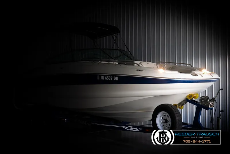 Slide: The Image of 2008 Crownline 240 EX boat on trailer in dimly lit storage. - 4