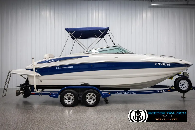 Slide: The Image of 2008 Crownline 240 EX boat with blue and white design on trailer in showroom. - 5