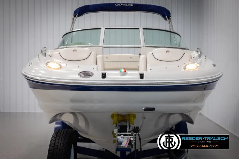 Slide: The Image of 2008 Crownline 240 EX boat in showroom, front view with blue accents and trailer. - 8