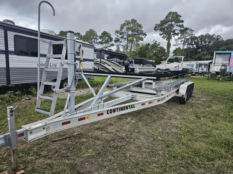 Slide: The Image of Continental boat trailer for 2010 World Cat 290 CC, parked outdoors near RVs. - 10