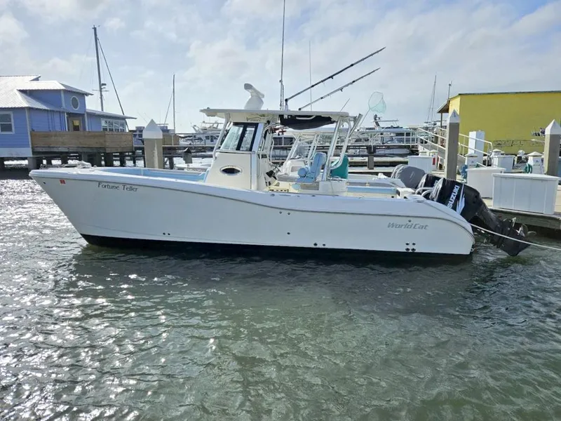 Slide: The Image of 2010 World Cat 290 CC boat docked at marina, clear sky, calm water. - 2
