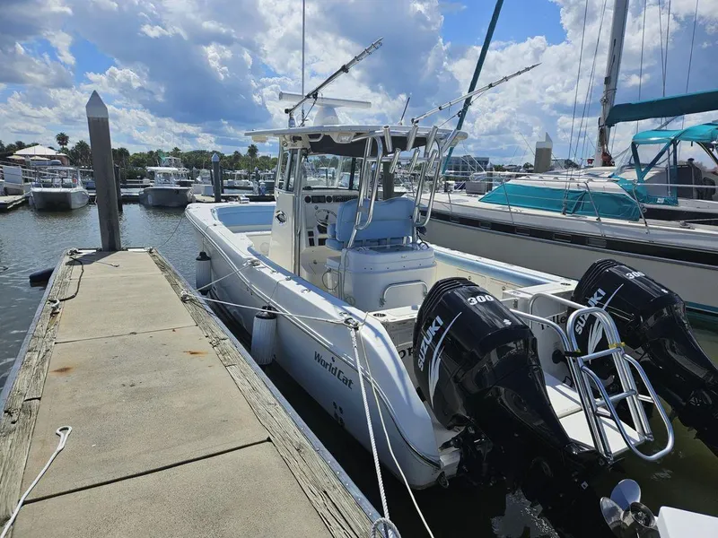 Slide: The Image of 2010 World Cat 290 CC boat docked with twin engines under a cloudy sky. - 4