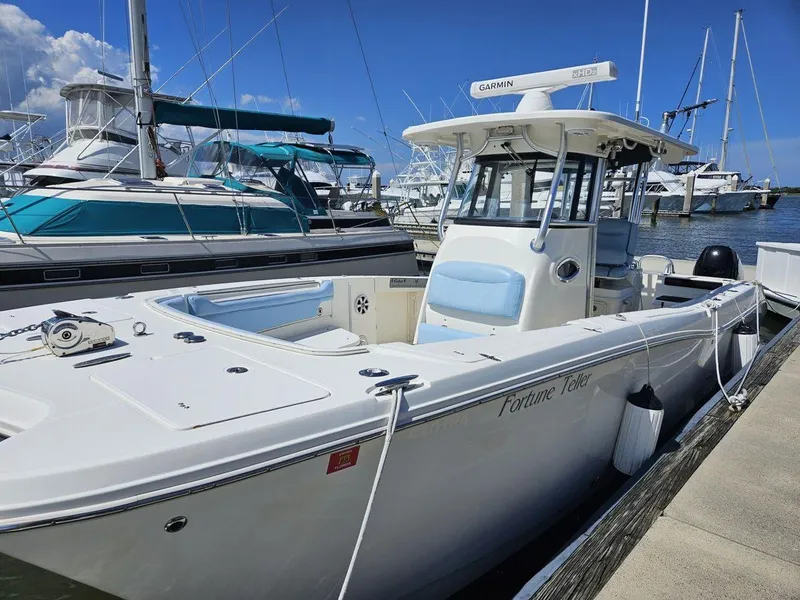 Slide: The Image of 2010 World Cat 290 CC boat docked at marina under clear blue sky. - 5