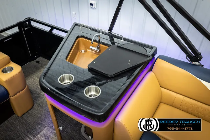 Slide: The Image of 2025 Avalon LSZ ELW boat interior with sink and cup holders, featuring luxury seating. - 27