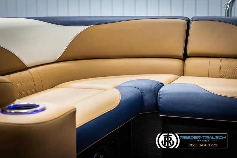 Slide: The Image of 2025 Avalon LSZ ELW boat interior with tan and blue seating, cup holder, and logo. - 39