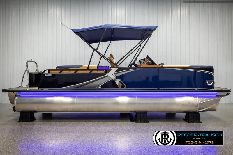 Slide: The Image of 2025 Avalon LSZ ELW pontoon boat with blue canopy and LED lights, displayed indoors. - 5