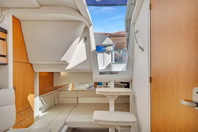 Slide: The Image of Interior of 2006 Sea Ray 300 Sundancer yacht, featuring modern seating and wooden accents. - 7