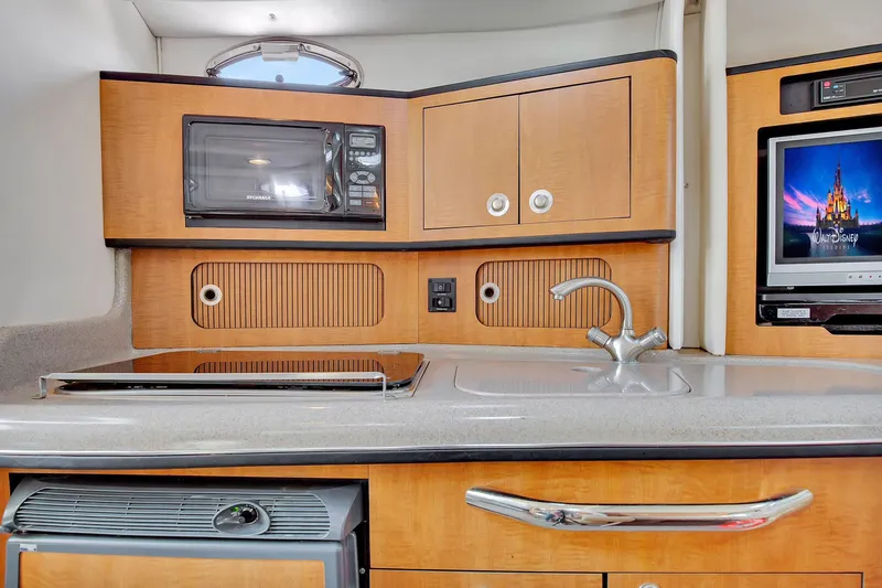 Slide: The Image of 2006 Sea Ray 300 Sundancer galley with microwave, sink, and TV. - 9