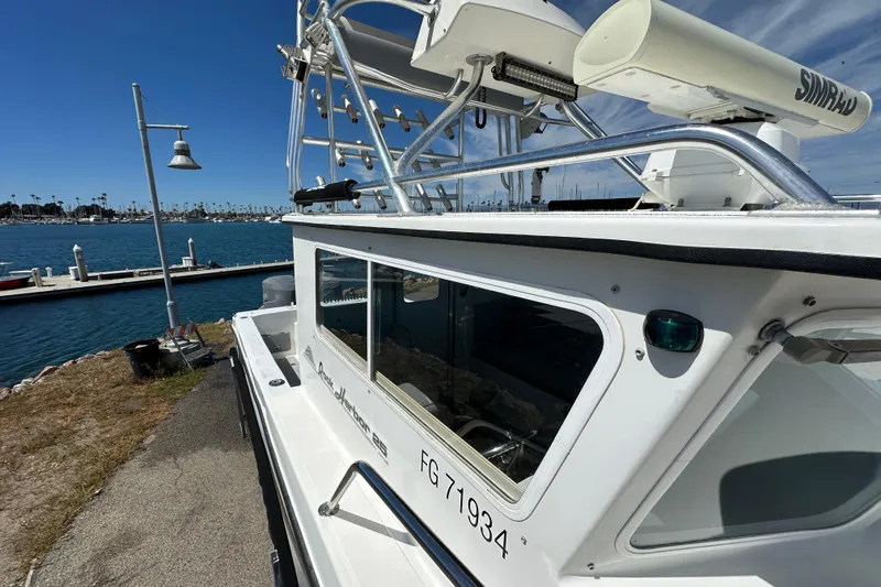 Slide: The Image of 2012 Davis Rock Harbor 25 boat docked by the marina under clear blue skies. - 12