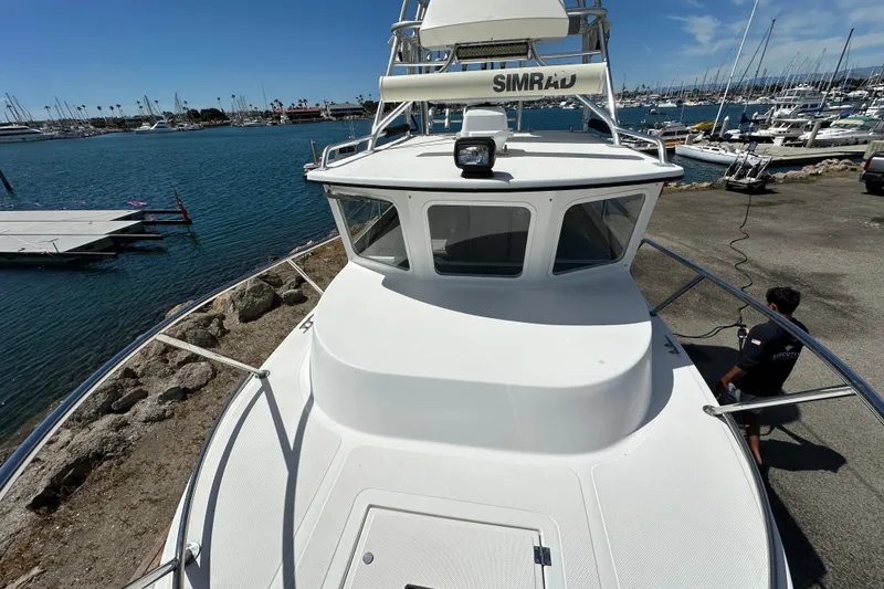 Slide: The Image of 2012 Davis Rock Harbor 25 boat docked at marina, clear sky, calm water. - 13