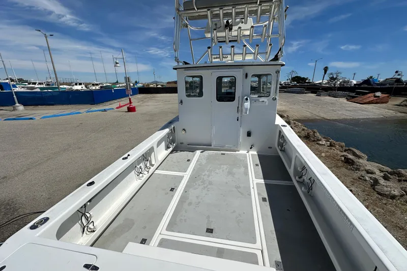 Slide: The Image of 2012 Davis Rock Harbor 25 boat docked, featuring spacious deck and fishing rod holders. - 17