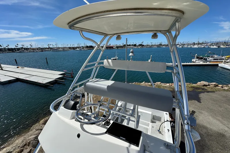 Slide: The Image of 2012 Davis Rock Harbor 25 boat with helm, docked in a marina under clear skies. - 26