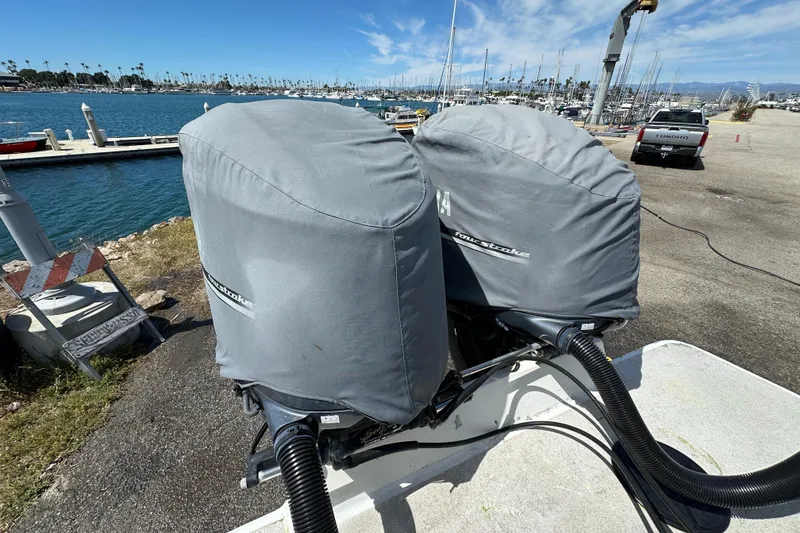 Slide: The Image of Twin outboard motors covered on a 2012 Davis Rock Harbor 25 boat by the marina. - 34