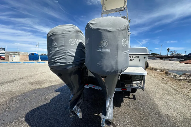 Slide: The Image of Twin Yamaha outboard motors on a 2012 Davis Rock Harbor 25 boat, parked on a sunny day. - 35