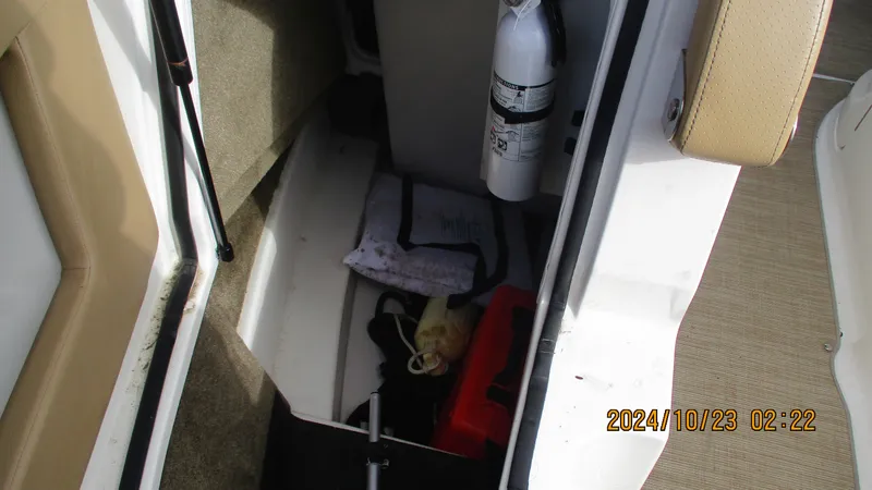 Slide: The Image of Storage compartment of 2020 Sea Ray SLX 250 with fire extinguisher and equipment. - 24