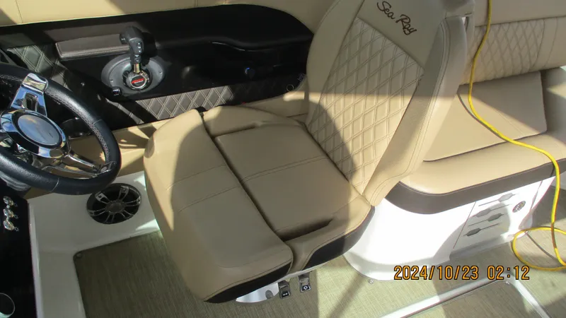 Slide: The Image of 2020 Sea Ray SLX 250 boat interior with beige leather seating and steering wheel. - 13