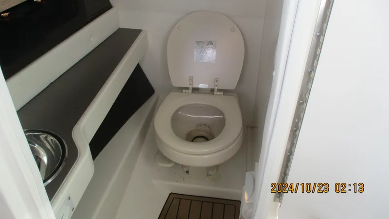 Slide: The Image of 2020 Sea Ray SLX 250 boat bathroom interior with toilet and sink. - 16