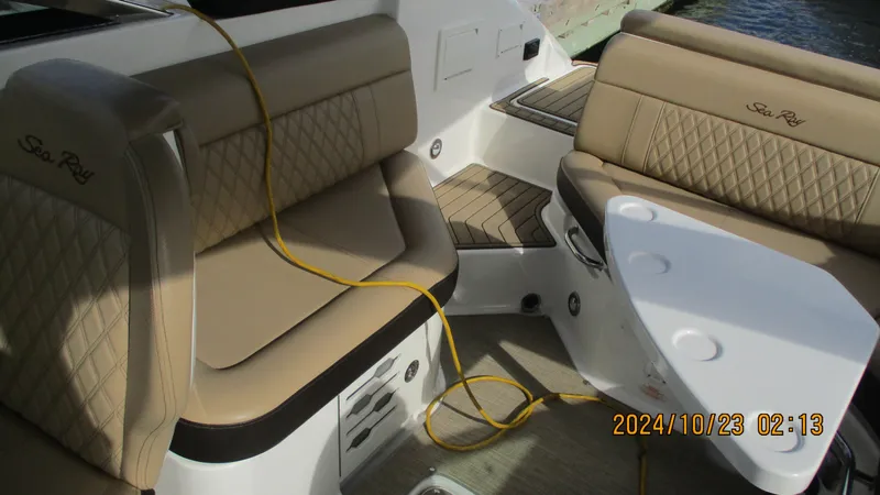 Slide: The Image of 2020 Sea Ray SLX 250 boat interior with tan leather seating and table. - 14
