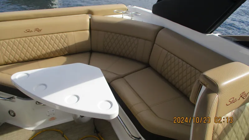 Slide: The Image of Luxurious seating on 2020 Sea Ray SLX 250 boat with tan upholstery and white table. - 15
