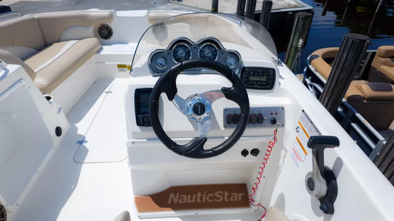 Slide: The Image of 2017 NauticStar 203 SC boat dashboard with steering wheel and gauges. - 13