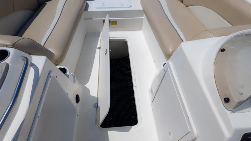 Slide: The Image of 2017 NauticStar 203 SC boat interior with open storage compartment and beige seating. - 27