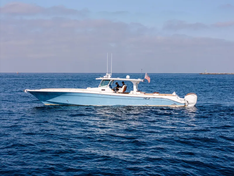 Slide: The Image of 2020 HCB 53 Sueños boat cruising on open water under a clear sky. - 3