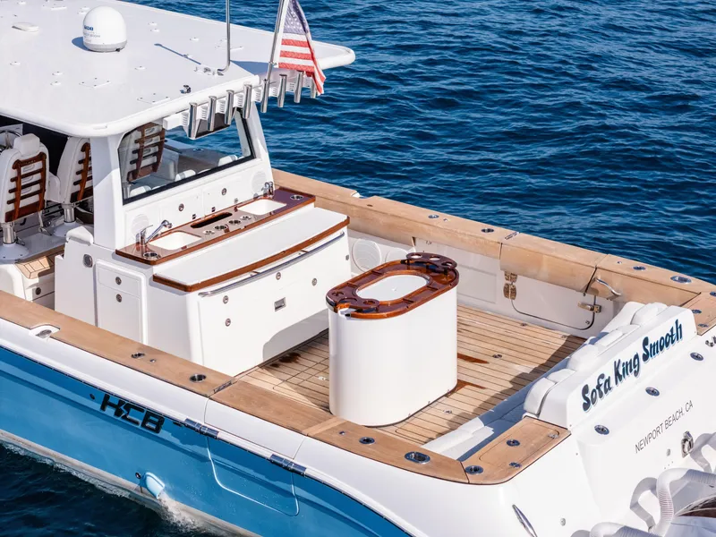 Slide: The Image of 2020 HCB 53 Sueños boat on water, featuring spacious deck and American flag. - 5