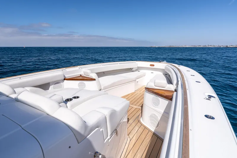 Slide: The Image of 2020 HCB 53 Sueños luxury boat on open sea, featuring spacious deck seating. - 6