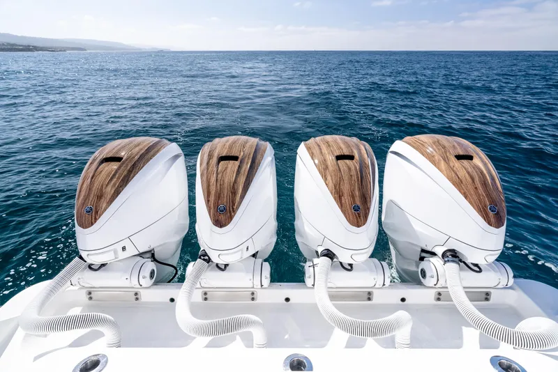 Slide: The Image of Four powerful outboard motors on a 2020 HCB 53 Sueños boat, ocean backdrop. - 10