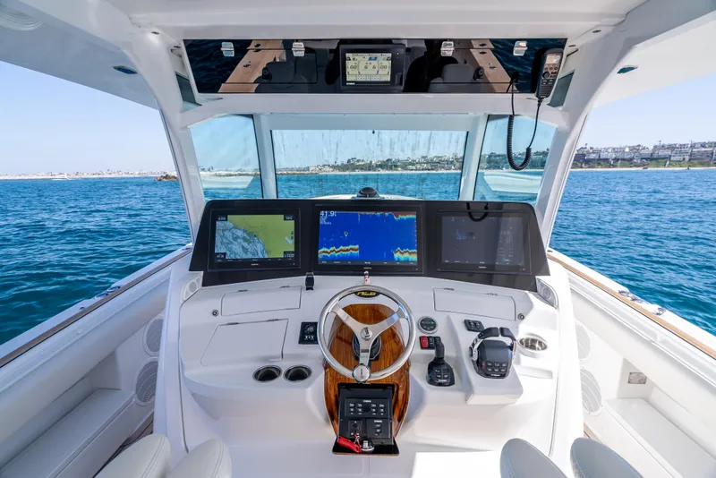 Slide: The Image of 2020 HCB 53 Sueños boat cockpit with advanced navigation screens on open water. - 15