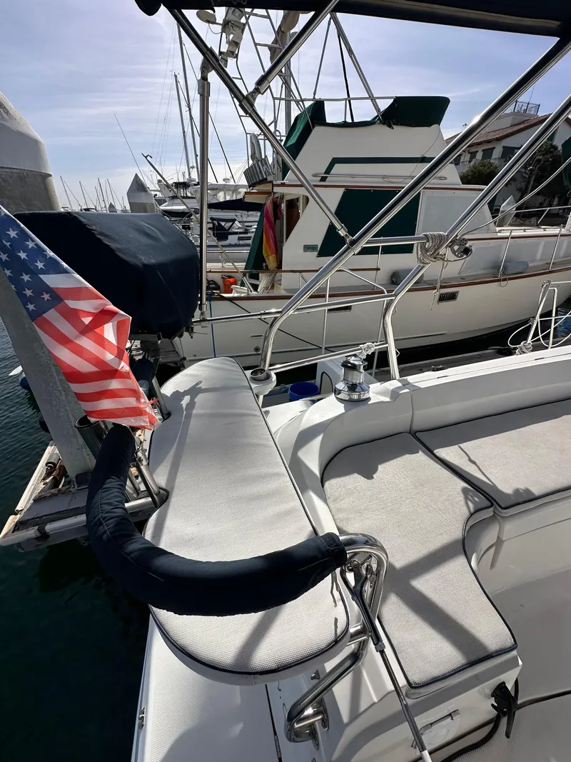 Slide: The Image of 2008 Hunter 38 sailboat docked with American flag, marina background. - 26