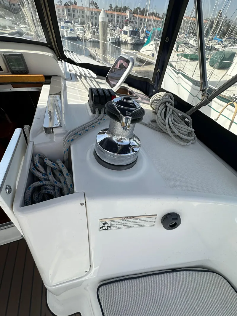 Slide: The Image of 2008 Hunter 38 sailboat cockpit with winch and ropes, marina background. - 35