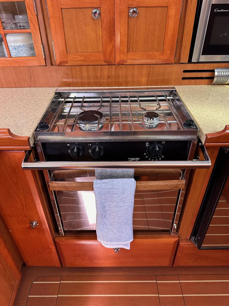 Slide: The Image of 2008 Hunter 38 yacht kitchen with stove and wooden cabinetry. - 47